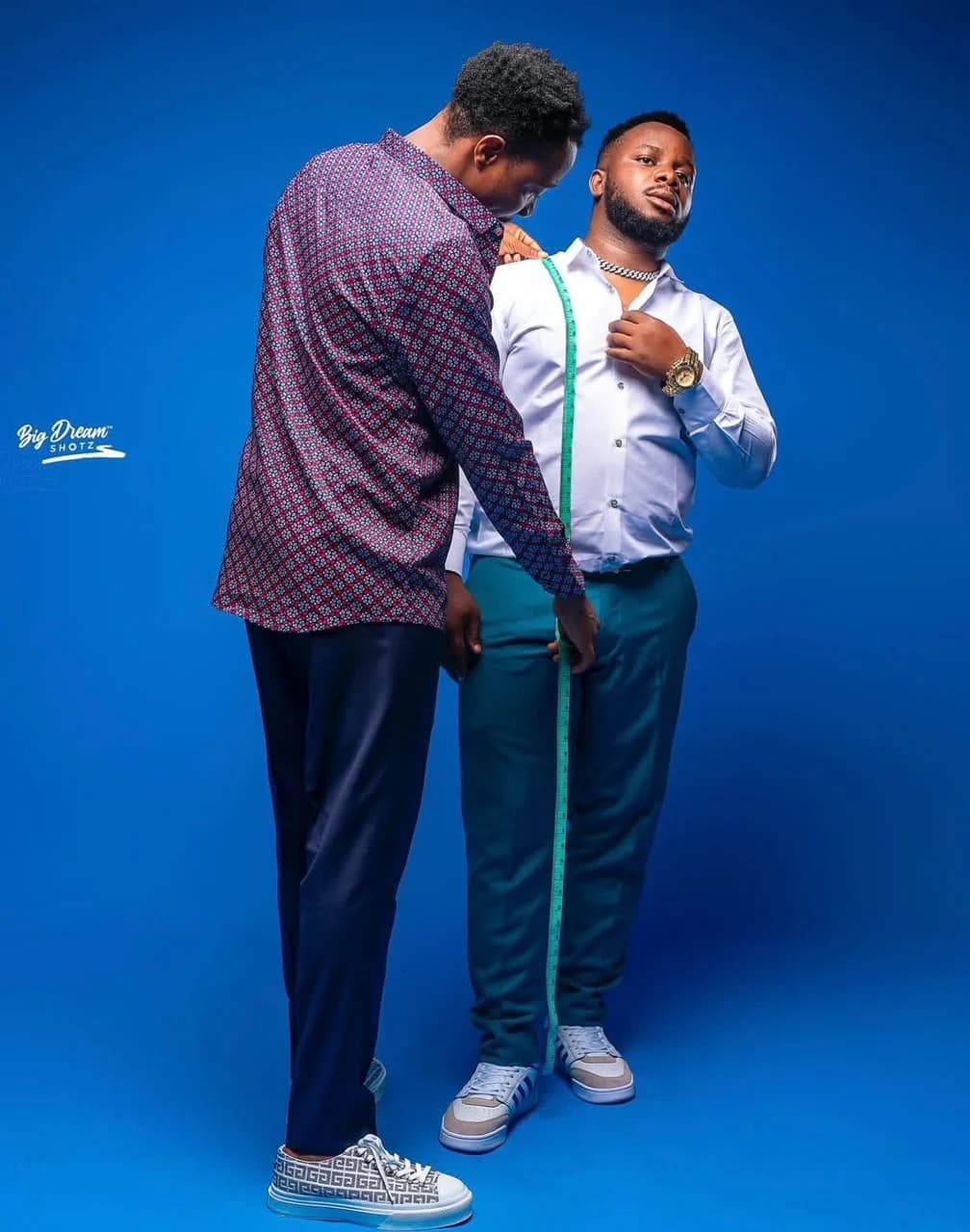 Taking measurements for a teal suit